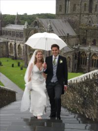 Wedding couple climbing steps of St Davids Cathedral