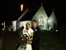 Wedding couple photographed in front of church at night
