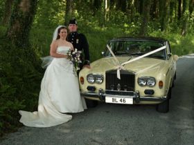 Wedding couple by Rolls Royce car